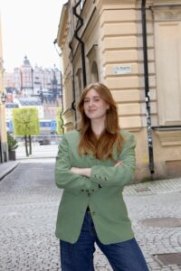 En kvinna med grön kavaj i Gamla Stan i Stockholm