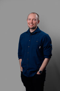 Anton Claesson, en kille som står upp med blå skjorta