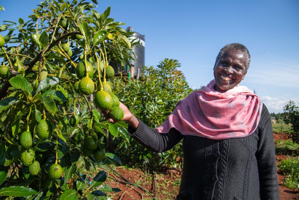 En glad kvinna som håller i en avokado