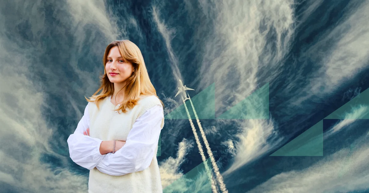 A woman standing in front of a sky background, with an airplane in the background.